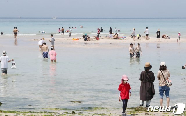 전국 대부분 지역의 낮 기온이 30도를 웃돌며 여름 더위를 보인 8일 오후 제주시 함덕해수욕장에서 관광객들이 물놀이를 하고 있다.2021.6.8/뉴스1 © News1