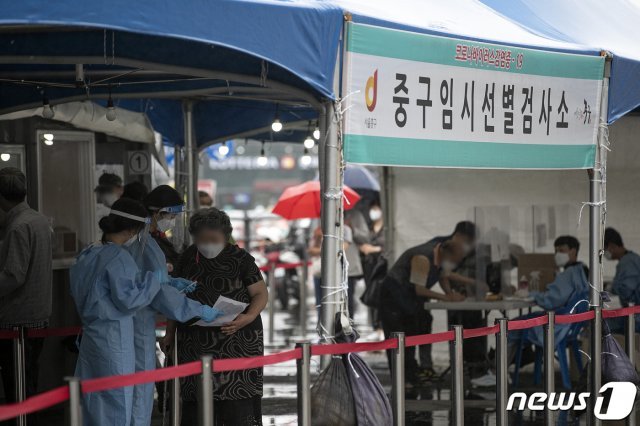 18일 오전 서울 중구 서울역광장에 마련된 신종 코로나바이러스 감염증(코로나19) 임시 선별검사소를 찾은 시민들이 안내를 받고 있다. 2021.6.18 /뉴스1 © News1