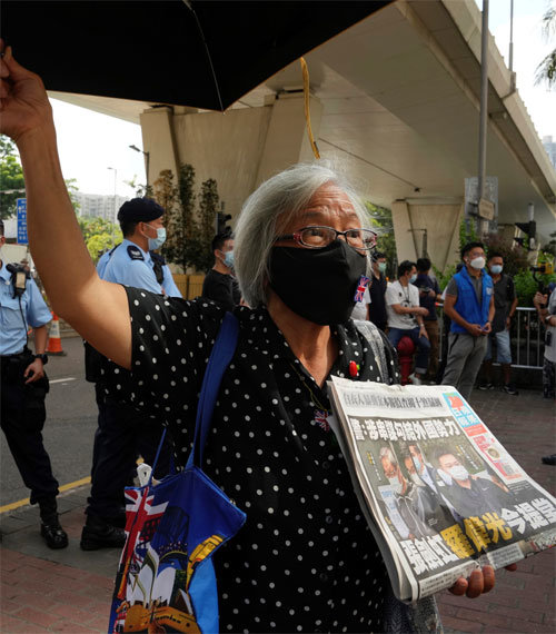 홍콩의 민주화 시위대가 19일 법원 근처에서 반중매체 핑궈일보를 들고 이틀 전 체포된 핑궈일보 간부들의 석방을 요구하고 있다. 홍콩=AP 뉴시스