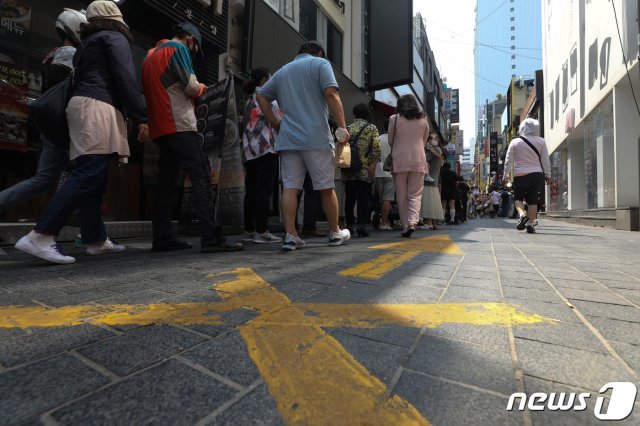 서울 명동거리의 한 식당에서 시민들이 식사를 하기 위해 줄을 서 있다./뉴스1 © News1