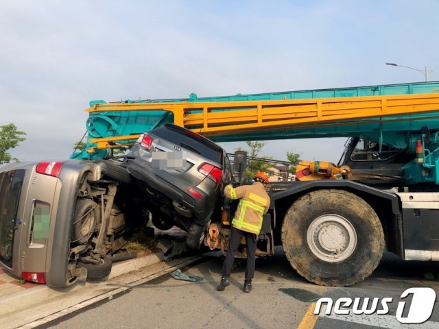 22일 오전 7시29분쯤 전남 여수시 웅천동의 한 공사현장 인근 도로에서 45톤 대형크레인이 도로 아래로 밀리며 주차되어있던 승용차 등 총 6대의 차량을 충격했다.(여수소방서 제공)2021.6.22/뉴스1 © News1