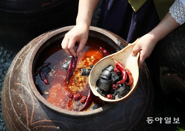 간장 본연의 맛을 살리고 불순물을 제거하기 위해 붉은 고추와 숯을 독에 넣고 있다.박영철 기자 skyblue@donga.com