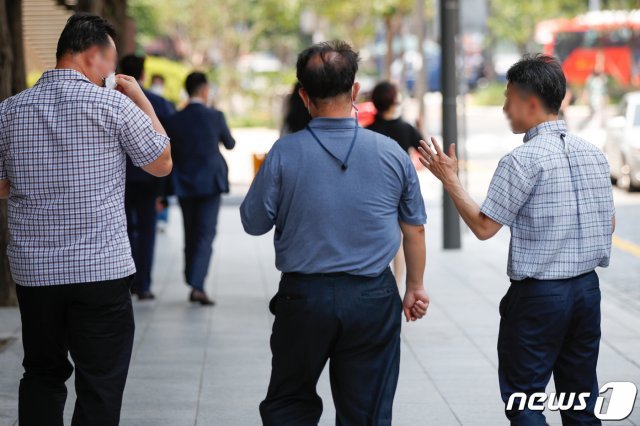 서울 시내에서 점심시간 이동하던 한 직장인이 마스크를 착용하지 않은채 대화하고 있다./뉴스1 © News1
