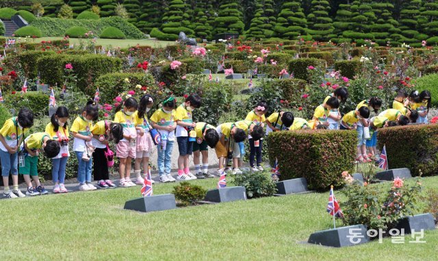 6·25전쟁 71주년을 하루 앞둔 24일 부산 남구 유엔기념공원에서 참전 유엔군 전몰용사 추모제가 열렸다. 행사장에 온 유치원생들이 묘역에서 묵념을 하고 있다. 세계 유일의 유엔군 합동 묘역인 유엔기념공원은 유엔군사령부가 참전했다가 숨진 유엔군 용사들을 매장하기 위해 1951년 4월 완공했다. 부산=박경모 기자 momo@donga.com