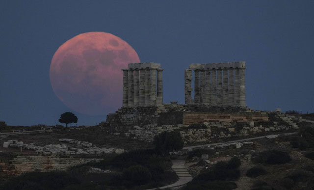 24일(현지시간) 그리스 아테네의 수니온곶에 있는 고대 포세이돈 신전 위로 ‘스트로베리 문‘으로 불리는 분홍빛 보름달이 걸쳐 있다. 뉴시스