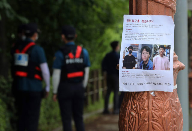 27일 경기 성남시 분당구 율동공원 인근 도로에서 경찰이 실종된 서현고 3학년 김휘성 군에 대한 수색 작업을 하고 있다. 가로수에 김 군의 가족들이 제작한 실종 전단이 붙어 있다. 성남=뉴스1