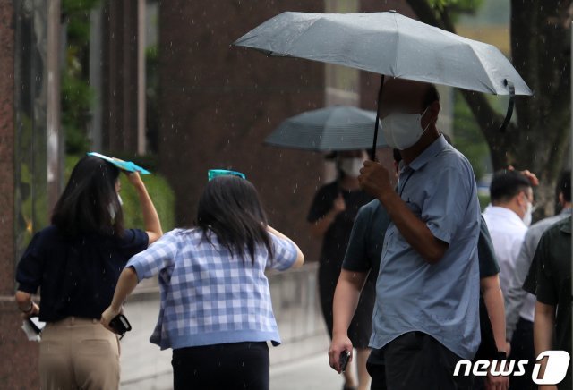 게릴라성 폭우가 내린 30일 서울 여의도환승센터에서 우산을 쓴 시민들이 점심식사를 위해 발걸음을 재촉하고 있다. 2021.6.30/뉴스1 © News1