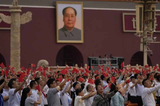 중국 공산당 창당 100주년 기념일인 1일 베이징 톈안먼 광장에 모인 중국인들이 마오쩌둥 전 주석의 대형 초상화 앞에서 오성홍기를 흔들고 있다. 베이징=AP 뉴시스