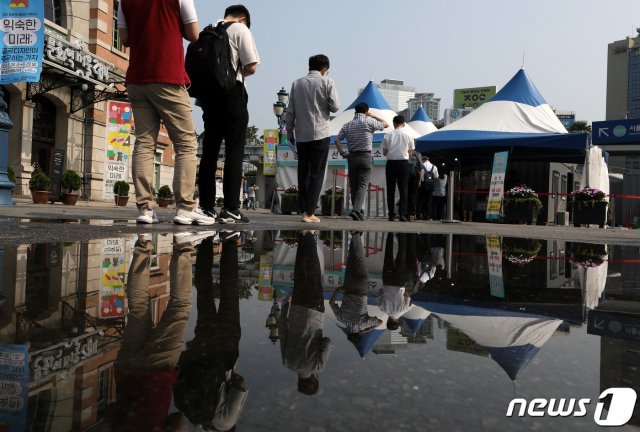 새로운 거리두기 앞두고 코로나19 확진자 수가 급증함에 따라 서울, 경기를 비롯한 수도권 개편안 적용 시점이 일주일 유예된 1일 오전 서울역 광장에 마련된 중구 임시선별진료소에서 시민들이 코로나19 검사를 위해 줄지어 기다리고 있다. 2021.7.1/뉴스1 © News1