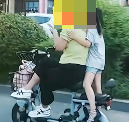위험천만하게 운전하는 여성·아이도 착석하지 않고 선 채로 어깨 넘어 휴대전화를 보고 있다. 웨이보