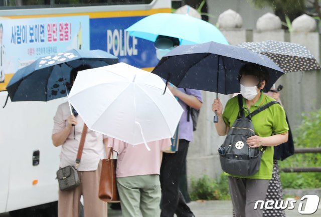 제주도를 시작으로 장마전선이 북상하며 전국적으로 장마가 시작된 3일 오후 서울 종로 거리를 지나는 시민들이 우산을 받쳐 들고 발걸음을 재촉하고 있다. 2021.7.3/뉴스1 © News1