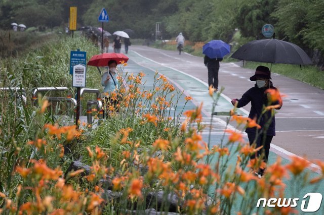 전국에 장맛비가 이어진 4일 서울 서대문구 홍제천을 찾은 시민들이 우산을 쓰고 산책하고 있다. 2021.7.4/뉴스1 © News1