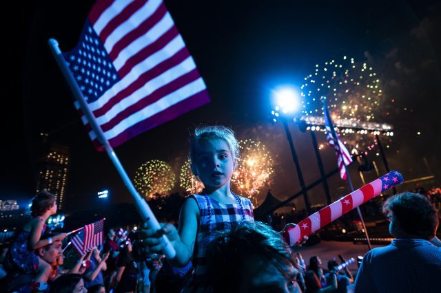 4일 저녁 뉴욕 이스트리버 인근에서 독립기념일을 축하하는 불꽃을 배경으로 한 어린이가 미국 국기를 흔들고 있다. AP 뉴시스