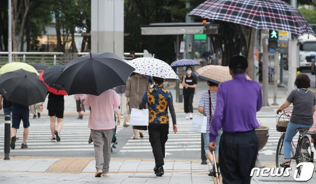 5일 오후 대구 도심 횡단보도에서 오락가락하는 장맛비에 우산을 쓴 시민들이 발걸음을 재촉하고 있다. 2021.7.5/뉴스1 © News1