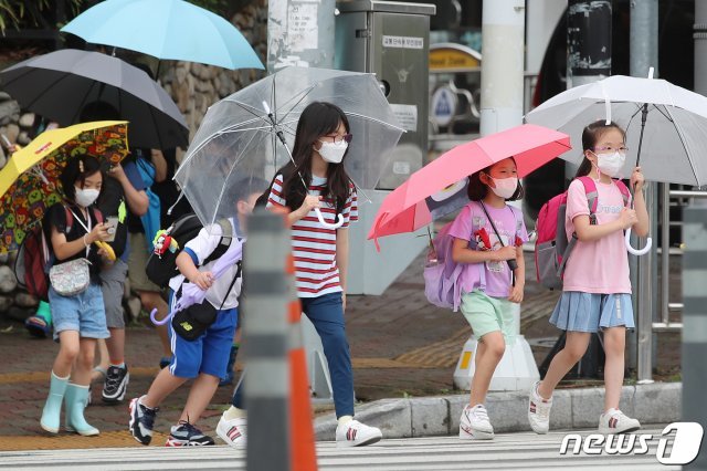 장맛비가 내리는 6일 오후 대구의 한 초등학교 앞 횡단보도에서 우산을 쓴 어린이들이 하굣길 발걸음을 재촉하고 있다. 2021.7.6/뉴스1 © News1