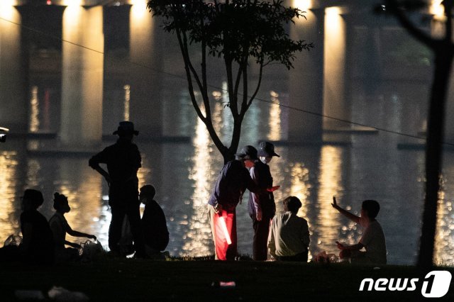 서울시 한강사업본부 직원들이 6일 밤 여의도 한강공원에서 시민들에게 10시 이후 야간 음주금지 안내 및 계도 활동을 하고 있다. 2021.7.6/뉴스1 © News1
