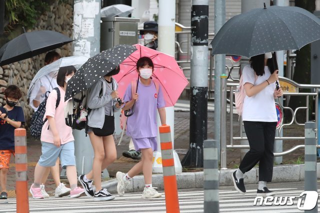 장맛비가 내리는 6일 오후 대구의 한 초등학교 앞 횡단보도에서 우산을 쓴 어린이들이 하굣길 발걸음을 재촉하고 있다. 2021.7.6/뉴스1 © News1