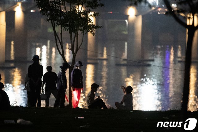 서울시 한강사업본부 직원들이 6일 밤 여의도 한강공원에서 시민들에게 10시 이후 야간 음주금지 안내 및 계도 활동을 하고 있다./뉴스1