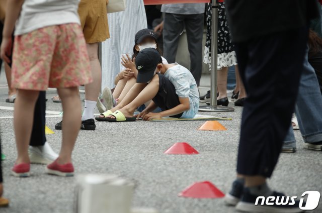 9일 오전 서울 강남구 보건소에 마련된 선별진료소를 찾은 어린이들이 바닥에 앉아서 검사를 기다리고 있다. 2021.7.9/뉴스1