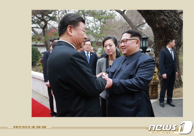 북한 외국문출판사가 12일 공개한 김정은 국무위원장 화보 ‘대외관계 발전의 새 시대를 펼치시어’. 김 위원장이 2018년 3월 중국을 방문해 시진핑 주석과 양원재에서 열린 오찬에 참석하며 악수하는 모습이 실려있다.(외국문출판사 화보 캡처) 2021.5.12/뉴스1