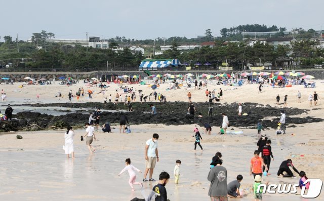 폭염특보가 발효 중인 11일 제주 곽지해수욕장에서 사람들이 물놀이를 하며 더위를 식히고 있다. 이날 제주 북부 낮 최고기온은 33도를 기록했다. 기상청은 지난 9일 제주 북부와 동부, 서부에 폭염주의보를 발효했다.2021.7.11/뉴스1