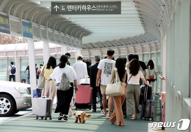 수도권과 제주지역 사회적 거리두기 격상을 하루 앞둔 11일 제주국제공항이 관광객으로 붐비고 있다. 오는 12일부터 수도권은 사회적 거리두기 4단계, 제주는 2단계를 시행한다. 전날 제주에서는 코로나19 확진자 24명이 발생했다. 2021.7.11/뉴스1 © News1