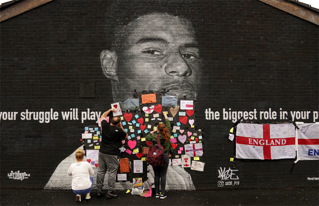 13일 영국 맨체스터 시민들이 유로 결승전 승부차기에서 실축한 마커스 래슈퍼드(잉글랜드)의 벽화에 응원 메시지를 붙이고 있다. 맨체스터=AP 뉴시스