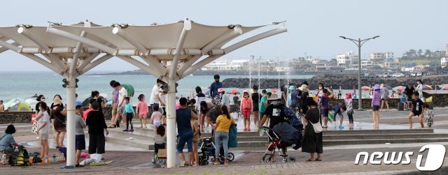 폭염특보가 발효된 지난 11일 제주 곽지해수욕장에서 사람들이 물놀이를 하며 더위를 식히고 있다. 이날 제주 북부 낮 최고기온은 33도를 기록했다. 기상청은 지난 9일 제주 북부와 동부, 서부에 폭염주의보를 발효했다.2021.7.11/뉴스1 © News1