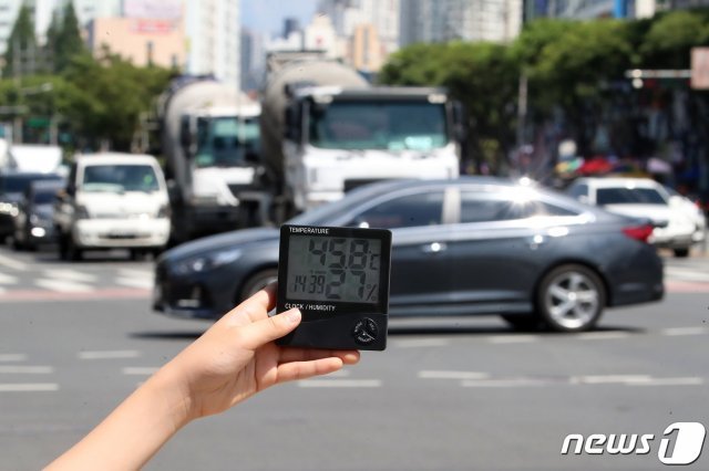 불볕더위가 이어진 14일 오후 대구 수성구 달구벌대로 횡단보도 앞에서 한 어린이가 손에 쥔 온도계가 45도를 넘어서고 있다. 2021.7.14/뉴스1 © News1