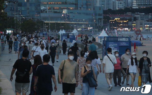 열대야 현상이 나타난 13일 오후 부산 해운대구 해운대해수욕장을 찾은 시민들이 더위를 쫓고 있다. 열대야는 오후 6시 1분부터 다음 날 오전 9시까지 최저기온이 25도 이상으로 유지되는 현상이다. 2021.7.13/뉴스1 © News1