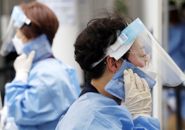 서울 동작구청 주차장에 마련된 임시 선별검사소에서 의료진들이 아이스팩으로 더위를 식히고 있다. 뉴시스