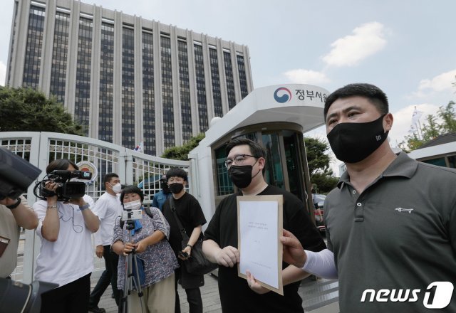 김기홍 코로나19 대응 전국자영업자비상대책위원회 공동대표 등이 16일 오후 서울 종로구 세종대로 정부서울청사 앞에서 거리두기 4단계 조치에 대한 자영업단체 입장문 발표 및 질의서 전달 1인 기자회견을 마친 뒤 국무총리실에 질의서를 전달하기 위해 이동하고 있다. 2021.7.16/뉴스1