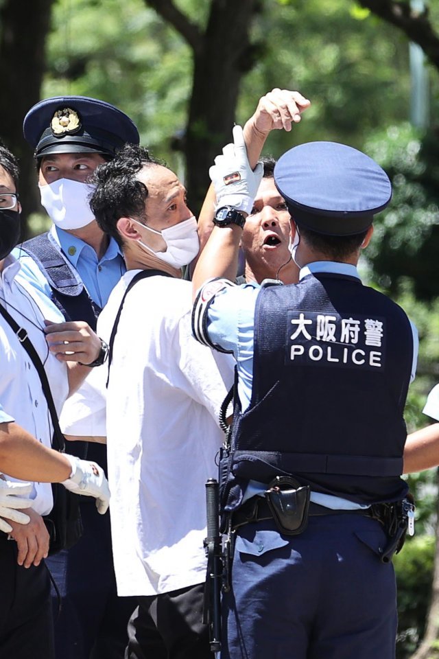 일본 극우단체 회원이 현장을 취재하던 한국 기자를 향해 달려들어 경찰이 제지하고 있다.  도쿄=올림픽사진공동취재단