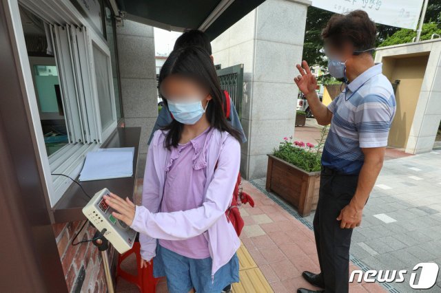 지난 7일 오전 서울 시내의 한 초등학교에서 학생들이 등교를 하며 체온측정을 하고 있다.  2021.7.7/뉴스1 © News1