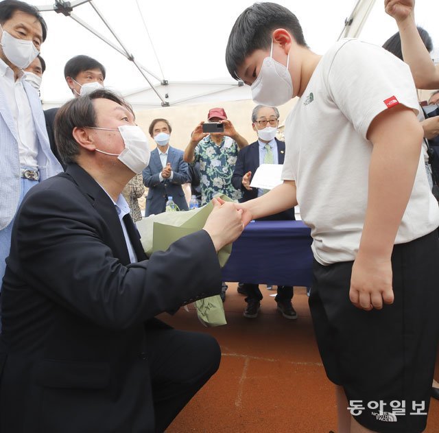 윤석열 전 검찰총장이 20일 대구 달서구 2·28민주의거기념탑에서 어린이로부터 꽃다발을 받고 “좋은 나라를 만들겠다”는 약속을 하고 있다. 대구=원대연 기자 yeon72@donga.com