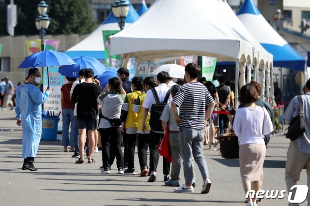 21일 오전 서울 중구 서울역광장에 마련된 신종 코로나바이러스 감염증(코로나19) 선별검사소를 찾은 시민들이 검사를 위해 줄 서 있다. 2021.7.21/뉴스1 © News1