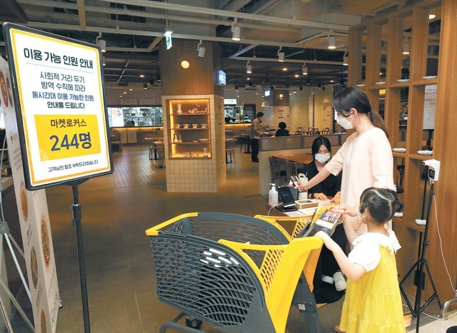 서울 성동구 이마트 성수점 푸드코트 입구에서 고객이 QR코드 체크인과 발열 체크를 하고 있다.