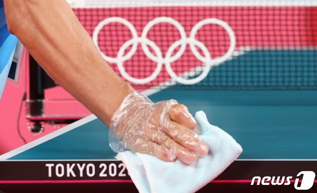 2020 도쿄 올림픽을 3일 앞둔 20일 일본 도쿄체육관에서 올림픽 관계자가 신종 코로나바이러스 감염증(코로나19) 확산 방지를 위해 탁구대를 소독하고 있다.  2021.7.20/뉴스1