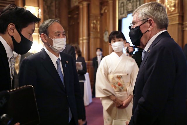 2021.07.18 토마스 바흐 IOC 위원장(오른쪽)과 스가 요시히데 일본 총리가 일본 영빈관 아카사카 궁전에서 열린 환영만찬에서 대화를 나누고 있다. AP =뉴시스