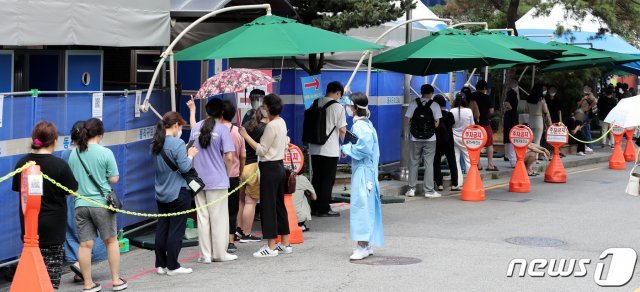 서울 동작구보건소 앞에 설치된 선별진료소를 찾은 시민들이 신종 코로나 바이러스 감염증(코로나19) 선별검사를 받기 위해 줄지어 기다리고 있다./뉴스1 © News1