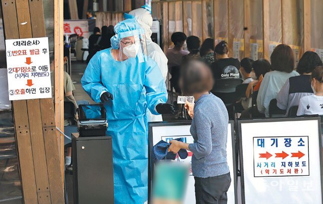 번호표 받고 코로나 검사 대기 22일 서울 송파구보건소 선별진료소에서 코로나19 검사를 받으러 온 
시민이 대기 번호표를 받고 있다. 송파구는 이날 서울 낮 최고기온이 35.9도까지 오르는 등 폭염이 계속되자 시민들이 더위를 피해
 검사 차례를 기다릴 수 있는 번호표 시스템을 도입했다. 양회성 기자 yohan@donga.com