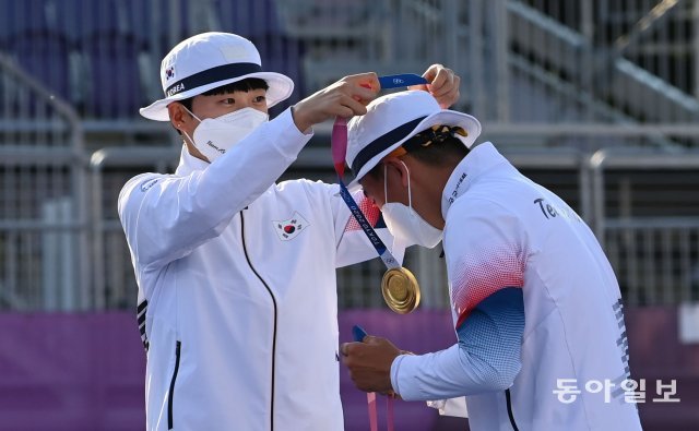 양궁 국가대표 김제덕(오른쪽)과 안산이 24일 일본 도쿄 유메노시마 공원 양궁장에서 열린 도쿄올림픽 양궁 혼성 네덜란드와의 결승전에서 승리한 뒤 금메달을 목에 걸고 환호하고 있다. 
2021.07.24 도쿄=홍진환 기자