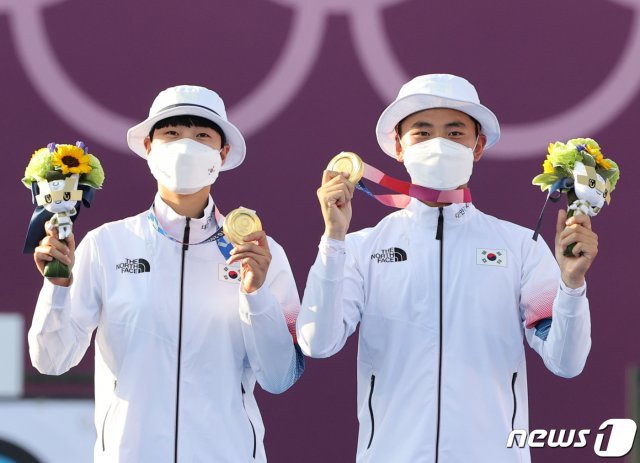 대한민국 양궁대표팀 안산과 김제덕이 24일 일본 도쿄 유메노시마 공원 양궁장에서 열린 2020 도쿄올림픽 혼성단체 결승전에서 승리했다. 안산과 김제덕이 금메달을 들고 포즈를 취하고 있다. 2021.7.24/뉴스1 © News1