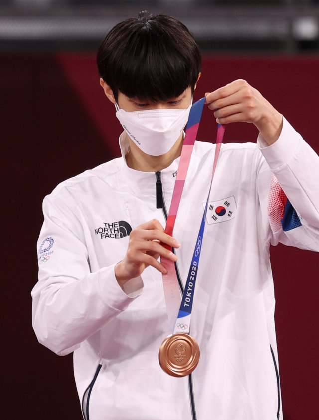 장준이 24일 지바 마쿠하리 메세 A홀에서 열린 도쿄올림픽 남자 태권도 -58㎏급에서 동메달을 차지한 뒤 받은 동메달을 바라보고 있다. 2021.07.24. 지바(일본)=뉴시스