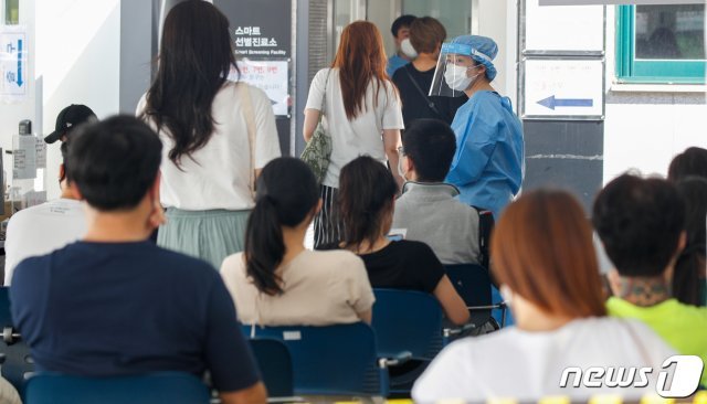 신종 코로나바이러스 감염증(코로나19) 신규 확진자가 1487명을 기록한 지난 25일 서울 강남구보건소에 마련된 코로나19 선별진료소에서 시민들이 검사를 기다리고 있다. /뉴스1 © News1