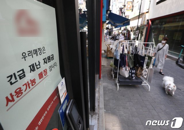 34조 9000억원 규모의 추가경정예산안이 국회를 통과한 가운데 25일 서울 명동거리의 한 매장에 재난지원금 결제가 가능하다는 안내문이 붙어 있다. /뉴스1DB