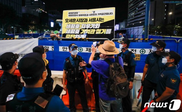 26일 저녁 서울 종로구 광화문 광장에서 한 시민이 마스크를 벗은 채 세월호 기억공간 쪽을 스마트폰으로 촬영하고 있다. 2021.7.26/뉴스1 © News1