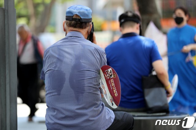 전국 대부분 지역에 폭염특보가 발효된 26일 서울의 한 거리에서 시민들이 그늘아래 더위를 식히고 있다. 2021.7.26/뉴스1 © News1