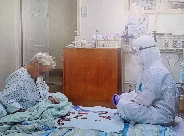 고령의 환자와 화투를 치는 의료진의 모습. 트위터 갈무리