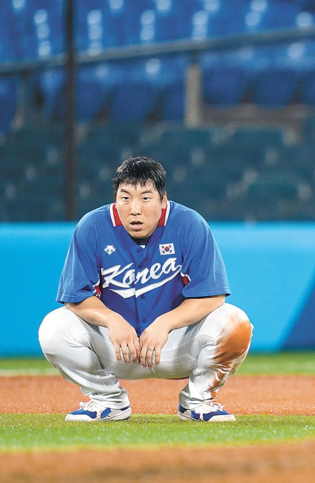 한국 야구 대표팀 주장 김현수가 4일 요코하마에서 열린 일본과의 준결승 경기에서 2루타를 치고 나간 8회초 공격 때 후속타 불발로 득점에 실패한 뒤 그라운드에 앉아 있다. 요코하마=AP 뉴시스